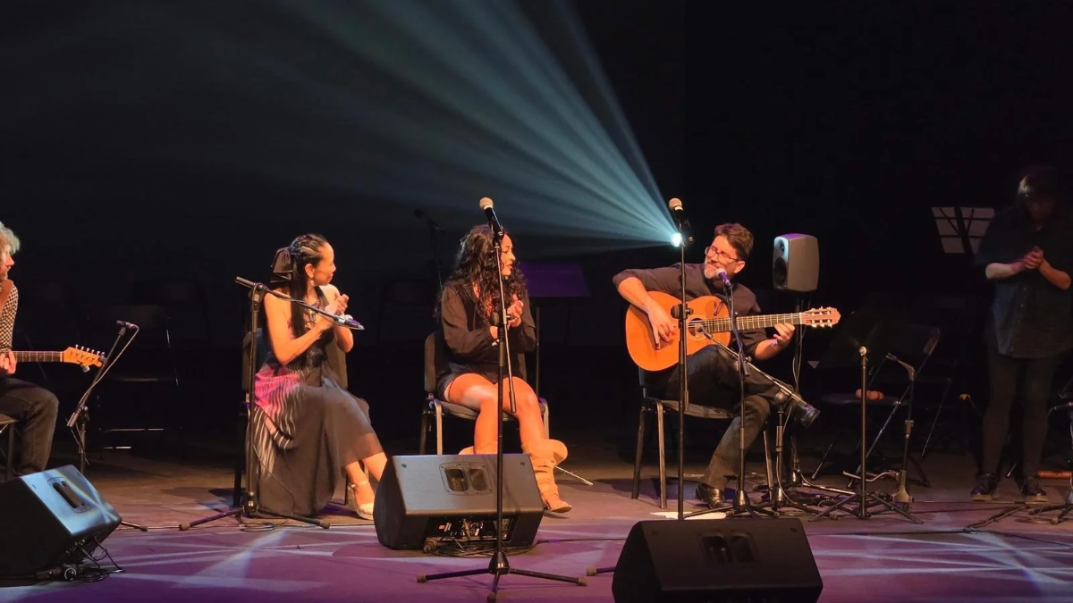 Dos cantantes y un guitarrista sobre el escenario del Teatro Bulevar de Torrelodones durante el concierto solidario por Venezuela